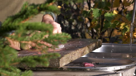 Autumn-in-Canadian-countryside,-senior-fisherman-preparing-fish-outdoors