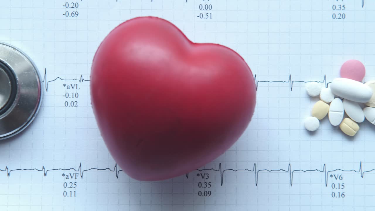 modelo de corazón con ecg, estetoscopio y pastillas