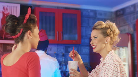 Two-Women-Talking-And-Smiling-In-An-American-Diner