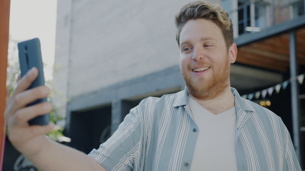 한 남자가 카페에서 비디오 통화를 하고 있다.