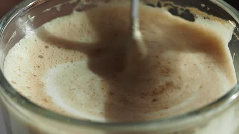 closeup of a coffee drink being stirred