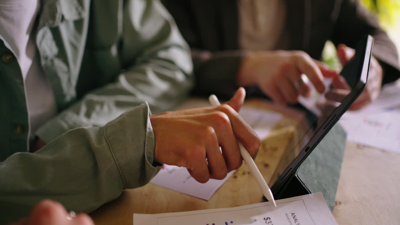 Business Meeting: A Team Discusses Charts and Data on a Tablet