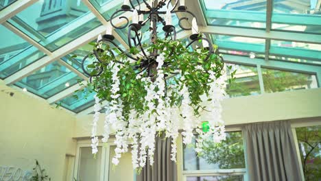 beautiful elegant black metal chandelier with hanging green leaves and white flowers