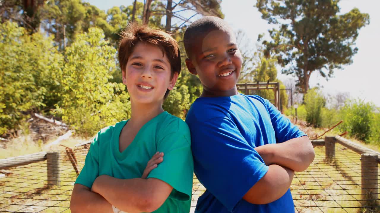 retrato de amigos felices de pie con los brazos cruzados durante una carrera de obstáculos