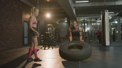 Vista-Frontal-De-Una-Monitora-Caucásica-Y-Un-Atlético-Afroamericano-En-El-Gimnasio.