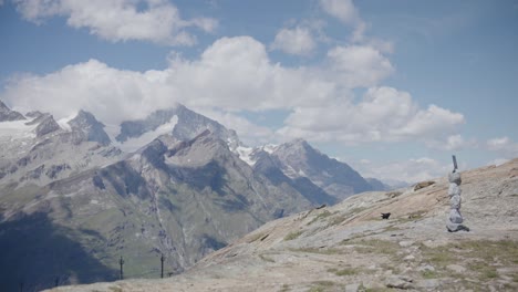 Bird-gliding-in-air-by-moutainside-as-black-male-traveler-with-back-pack-walks-near-Matthorn-in-Switzerland