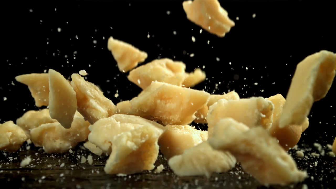 Parmesan Cheese Chunks and Grated Flakes Falling in Slow Motion