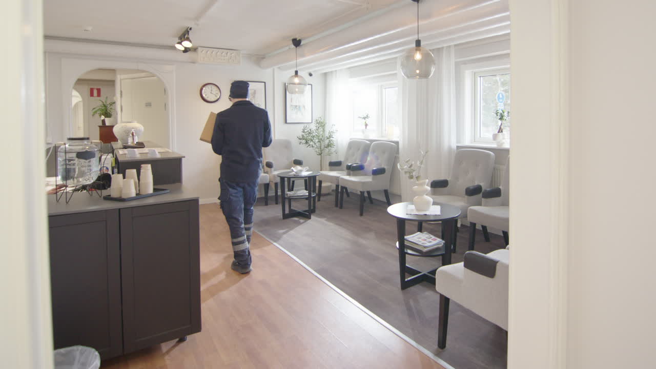 A courier man delivers a parcel to the waiting room reception of a company