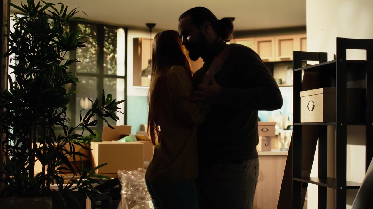 Couple Dancing Together in Their New Home Surrounded by Moving Boxes