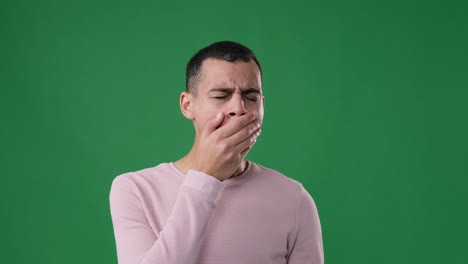 sleepy man yawning over green background