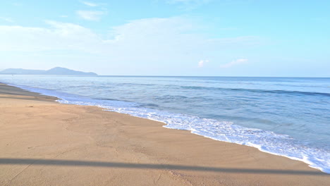 tropical sea waves breaking on sandy exotic beach at evening sun, slow motion