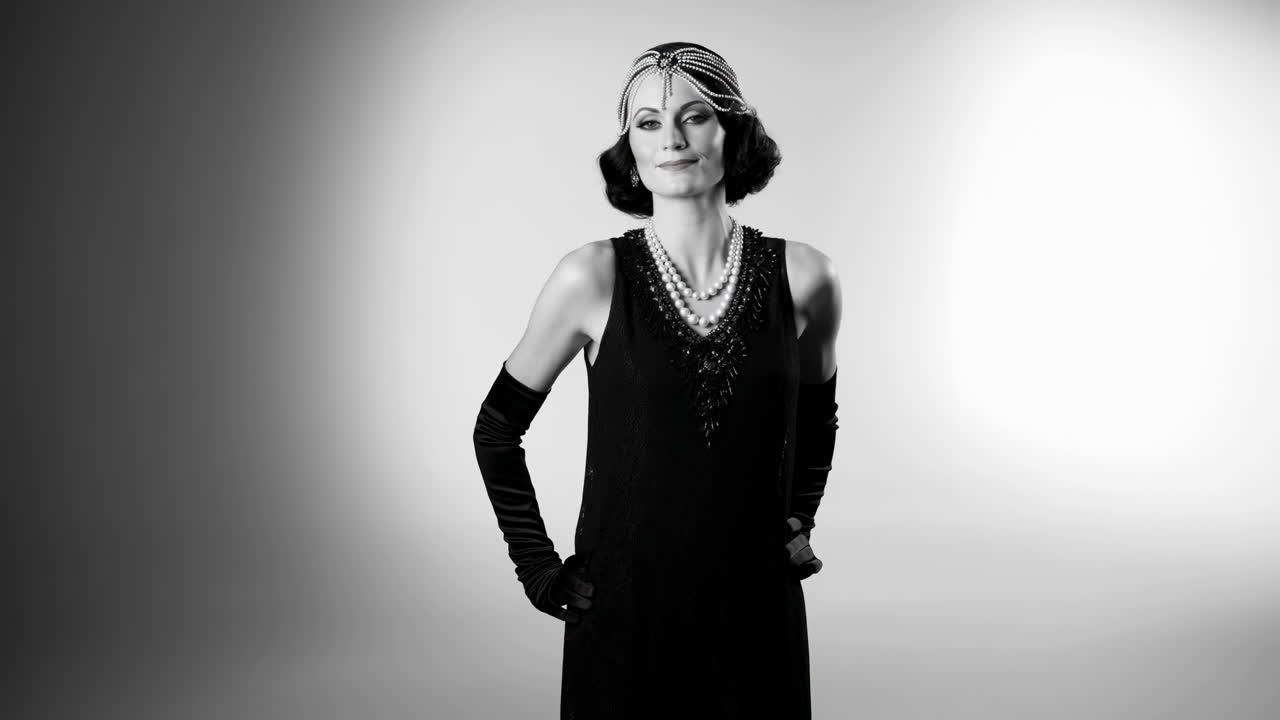 Donna elegante in abito da ballerina degli anni '20 e perle che posa in studio