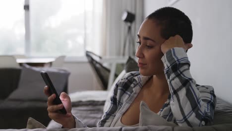 woman using smartphone and smiling in living room