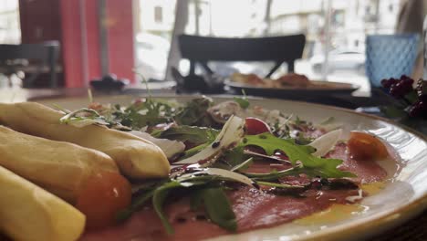 restaurant appetizer with jamon and breadsticks