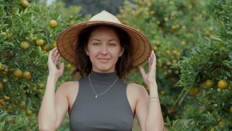 woman in straw hat in an orange orchard