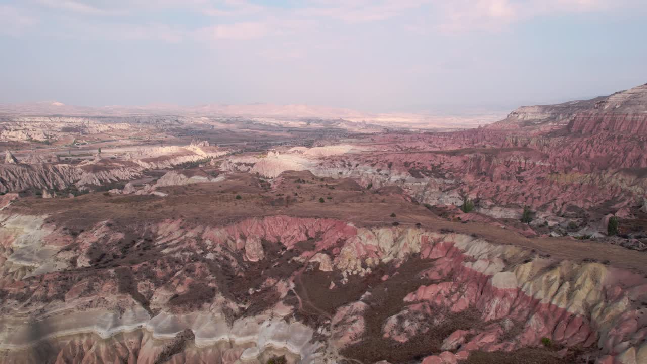 Aerial drone pan shot over Red Valley with it's spectacular volcanic shaped rocks, located in Cappadocia, Turkey on a cloudy day