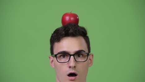 young shocked nerd man with apple on head