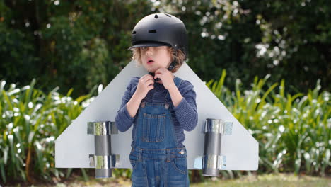 cute little boy wearing toy airplane wings happy child playing game pretending to fly imagining travel freedom having fun outdoors in sunny park enjoying childhood