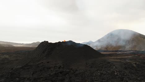 Aerial-view-of-the-volcano-erupting-at-Litli-Hrutur,-Iceland,-with-lava-and-smoke-coming-up