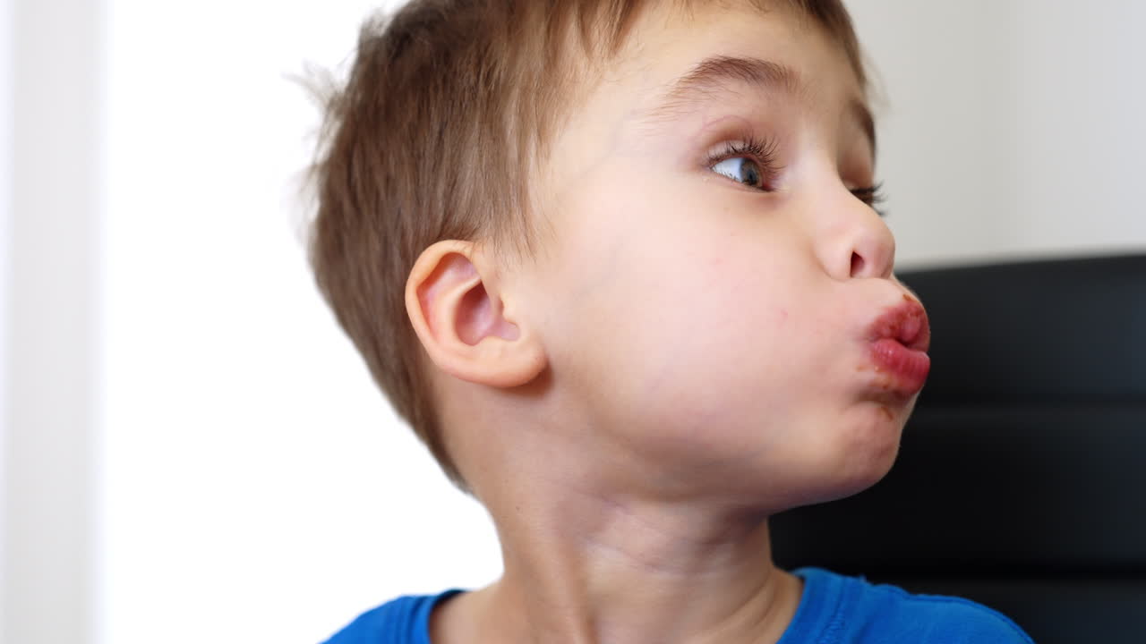 Child loves chocolate snack. Young boy sits at a table savoring a delicious chocolate snack, displaying joy and curiosity in his expression