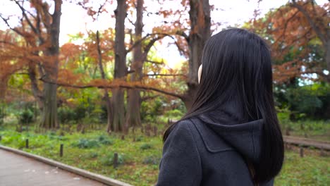 Niña-Japonesa-Caminando-Bajo-Las-Hermosas-Hojas-De-Otoño,-Tokio,-Japón