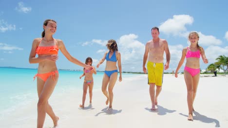 familia caucásica despreocupada en traje de baño descalza en la playa
