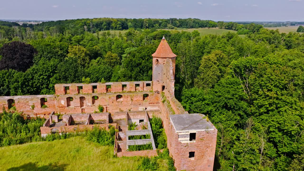 Aerial view showing ruins of Szymbark Castle surrounded by green forest