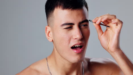 man tweezing his eyebrows
