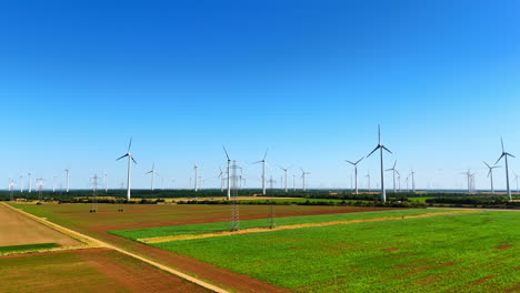 footage over the field along the electricity power lines and wind farms. green energy concept