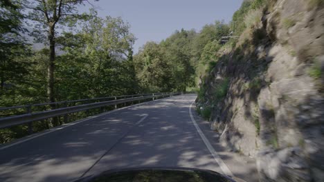 Driving-on-a-narrow-mountain-road-in-a-forest-in-the-Italian-Alps