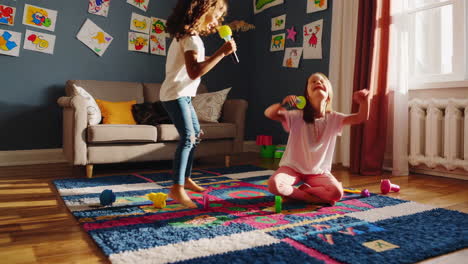 two young girls sing and dance with microphones during a home karaoke session