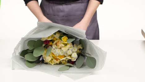 florist wrapping a bouquet of mixed flowers