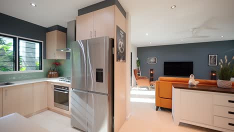 modern open-plan kitchen and loungeroom with sleek furnishings and natural lighting in a contemporary townhouse. interior of house home staged for real estate.