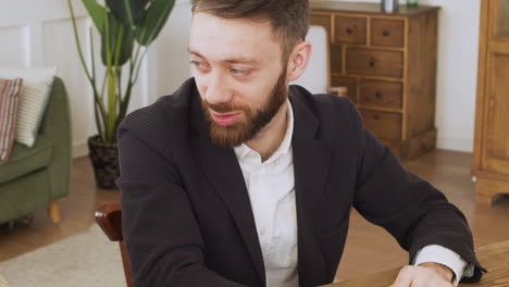 Close-up-of-three-multiethnic-colleagues-sitting-at-table-and-having-a-debate-during-a-team-meeting