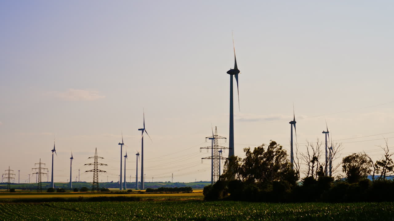 Turbines produce clean energy. Large wind turbines stand tall in a rural landscape, showcasing sustainable power generation during sunset