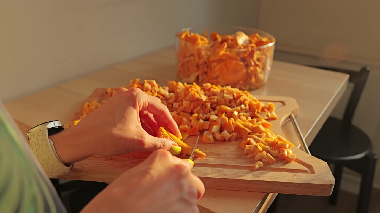 Chanterelle picked from glass bowl, cut on board in warm glowing sunlight