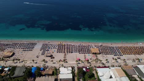 summer vacation hotels and paradise beach with umbrellas near blue turquoise sea in mediterranean, albania