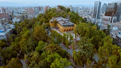 dron aéreo volando hacia el edificio cultural amarillo castillo en la colina de santa lucia, santiago chile chiloe 4k