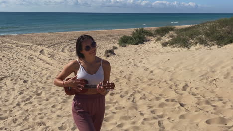 woman playing ukulele on a beach