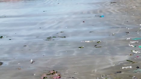 aerial flying over beach with litter strewn across sand
