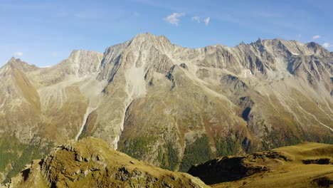 Passing-over-mountainous-landscape-with-high-mountain-peaks-in-the-background-Autumn-colors-in-Arolla,-Valais---Switzerland