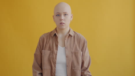 bald woman with arms crossed