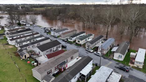 Parque-De-Casas-Rodantes-Con-Río-Inundado-En-El-Fondo-Durante-El-Invierno