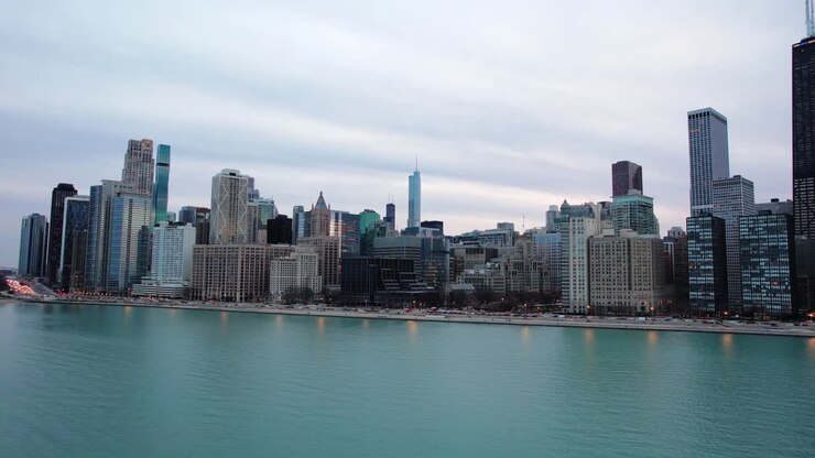 Revelando a bela Chicago em voo lateral ao pôr do sol acima da água do Lago Michigan.