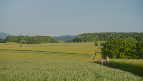 view of rural landscape with two men walking along dirt road