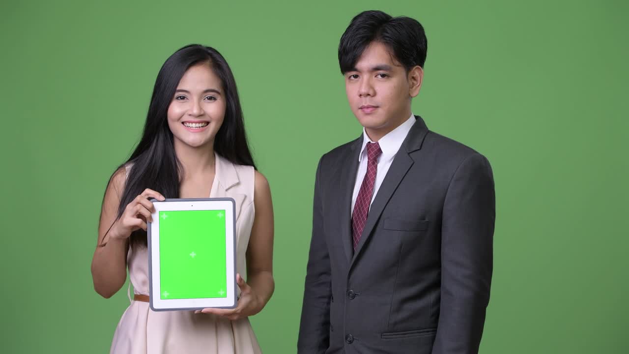 젊은 아시아 비즈니스 커플이 녹색 배경에 함께