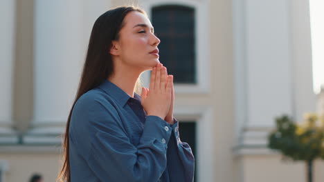 retrato de una mujer orando con los ojos cerrados a dios pidiendo bendición ayuda perdón al aire libre