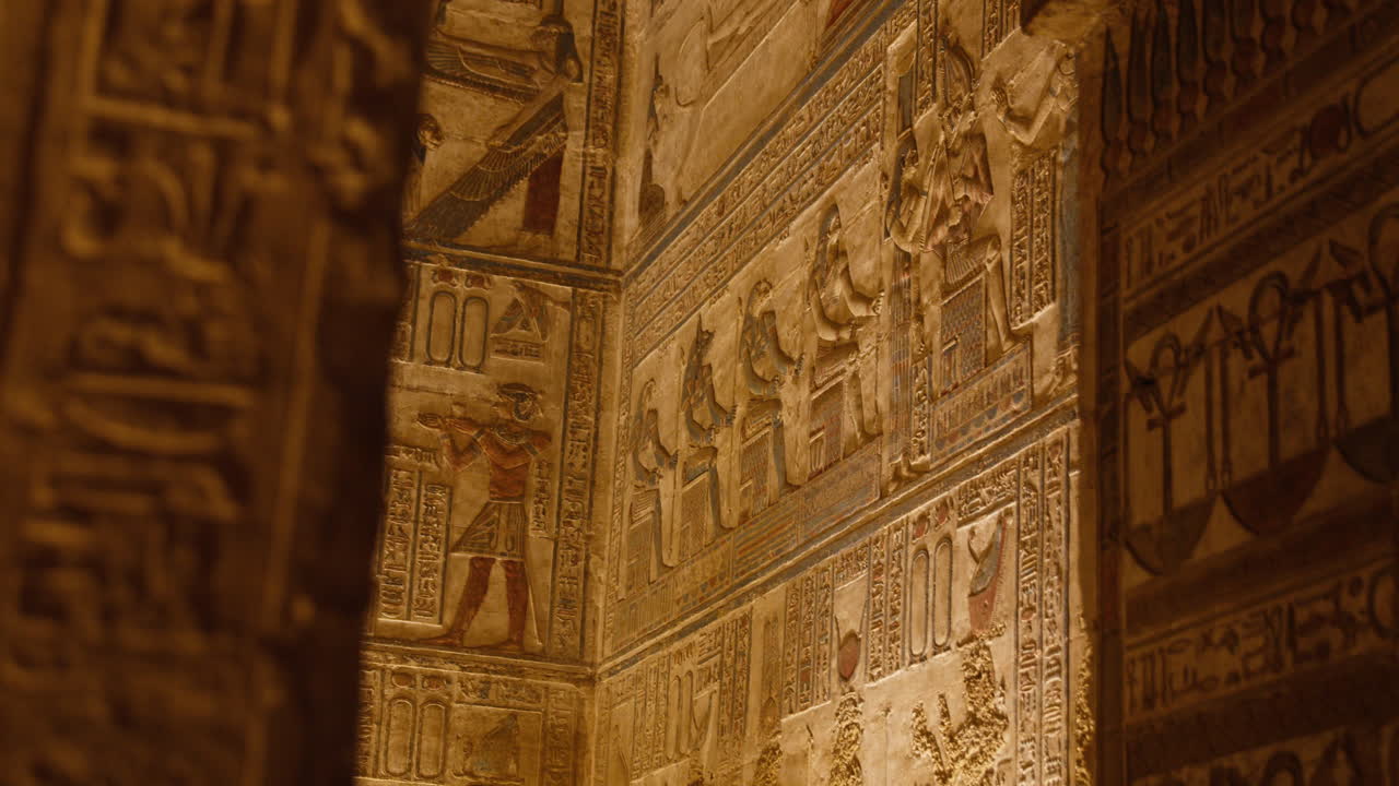Ancient Egyptian carvings lit warmly inside Dendera temple, Egypt