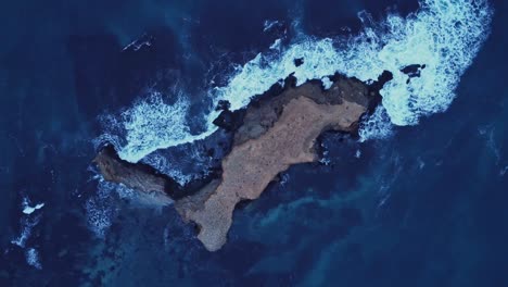 island surrounded with waving sea water