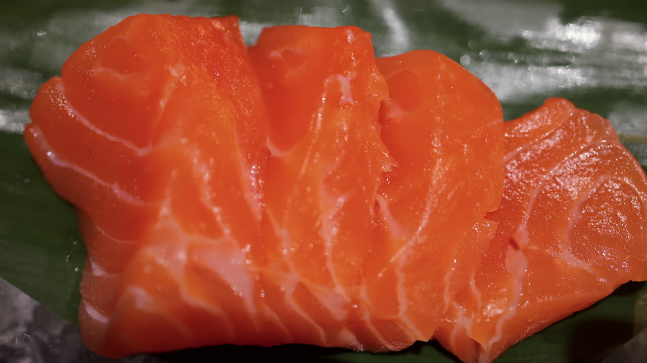Detailní záběr tuňáka a sashimi z lososa na banánových listech na ledu